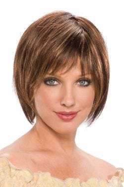 Woman in a chin length medium brown rounded bob wig with fringe bangs