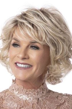 Woman in a large chin length light blonde curly bob wig with side bangs