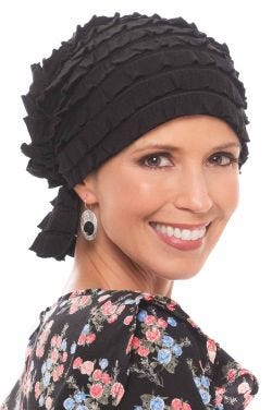 Woman in black chemo beanie head covering with black ruffled fabric