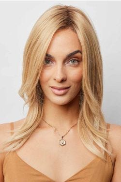 Woman in a past the shoulders blonde human hair wig with long layers