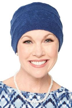 Woman in blue terry cloth turban in beanie style for women with cancer