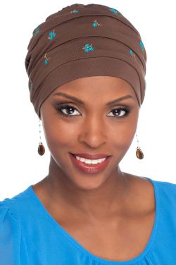 Woman in brown turban style embroidered sleep cap for cancer patients and women with hair loss