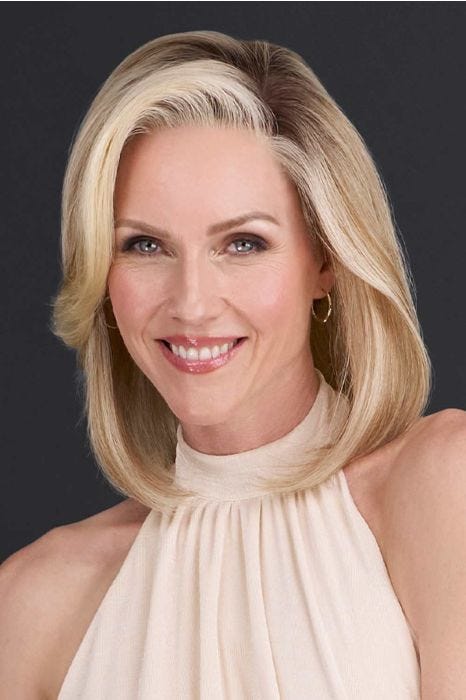 Woman in just past the shoulder wavy blonde wig with highlights and light layering