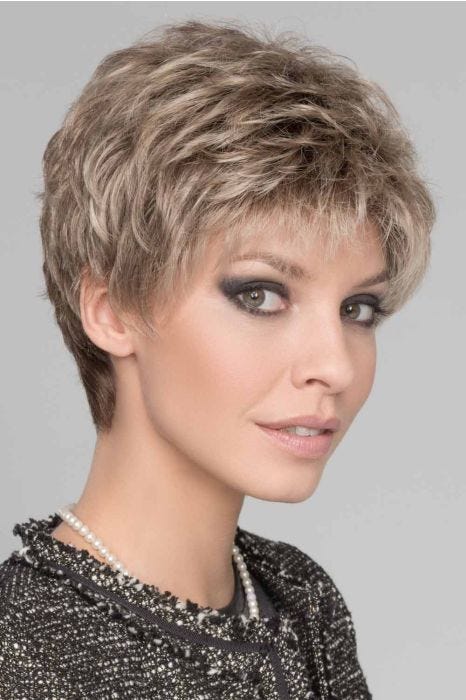 Woman in a petite evenly layered light brown curly lace front pixie wig