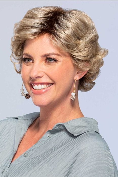 Woman in short curly blonde wig with bangs and layers for an older woman
