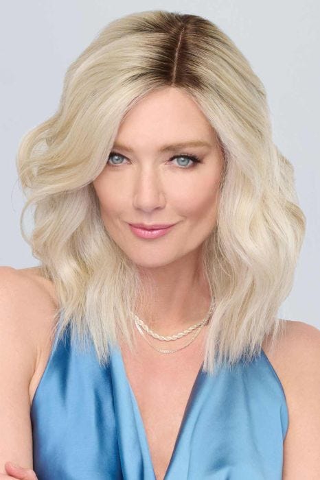 Woman in a past the shoulders platinum blonde lace front wavy wig
