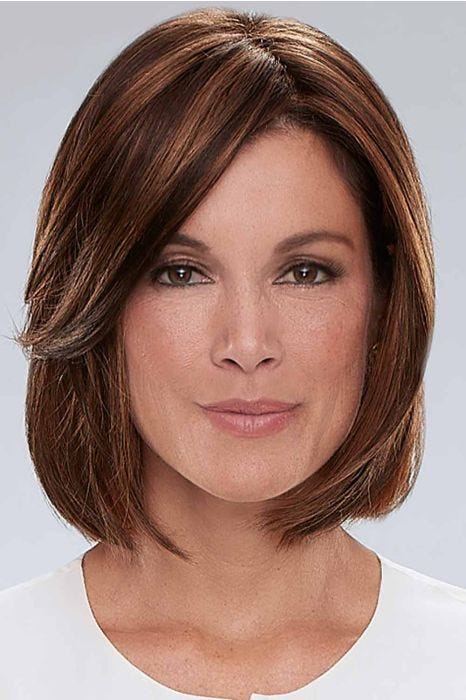 Woman in a shoulder length medium auburn wig with long side bangs