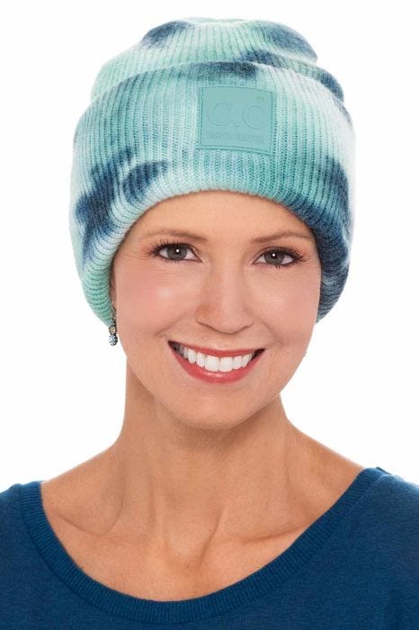 Woman in cute ribbed tie dye turquoise cuffed beanie hat for cancer patients