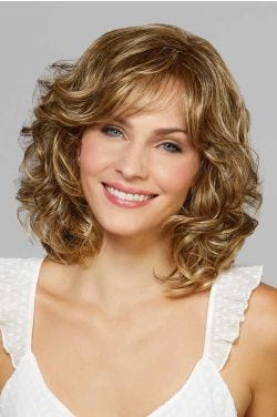 Woman in a shoulder length curly light ash brown wig with textured bangs