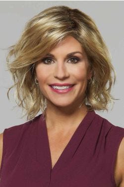 Woman in a shoulder length gold blonde curly bob wig with layers