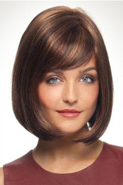 Woman in an angled chin length medium auburn bob wig with side bangs