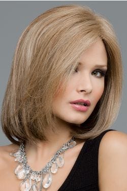 Woman in a dark blonde past the shoulders straight wig with a side part