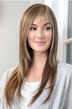 Woman in straight blonde long wig with bangs and light layers