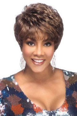 Afro American woman in a full medium brown pixie wig with longer layers on top and textured bangs