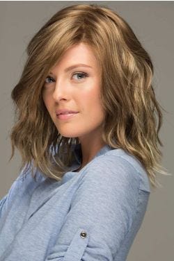 Woman in a shoulder length platinum blonde lace front wig with beach waves and dark roots