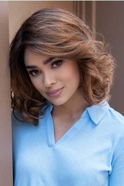 Woman in a shoulder length medium auburn curly lace front wig