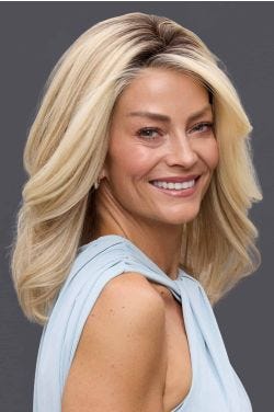 Woman in a past the shoulders medium auburn human hair wig with long layers