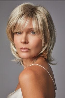 Woman in a shoulder length medium brown bob wig with side bangs and long layers