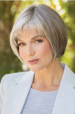 Woman in a chin length platinum blonde blunt bob wig with choppy textured bangs