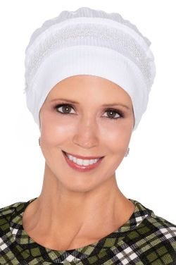 Woman in white beanie cap turban with embroidered detail for women with cancer Woman in white beanie cap turban with embroidered detail for women with cancer