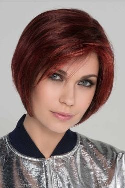 Woman in an angled dark red chin length bob wig with face framing layers