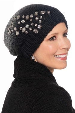 Woman in cute black winter beanie hat with slouchy back and embellished beading on the sides for cancer patients