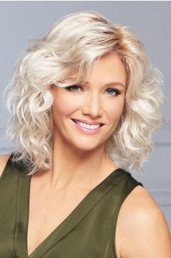 Woman in a shoulder length platinum blonde curly lace front wig with side bangs