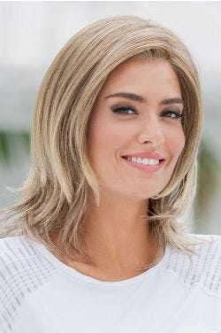Woman in a shoulder length blonde wig with choppy layers
