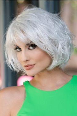 Woman in a chin length silver wavy wig with fringe bangs