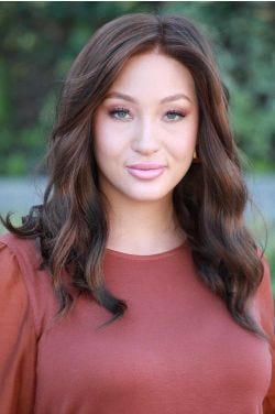Woman in a past the shoulders dark brown curly lace front wig