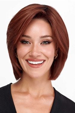 Woman in a chin length warm blonde wig with choppy layers and side bangs