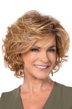 Woman in a large past the chin light auburn curly layered bob wig