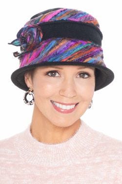 Woman in blue tweed winter hat with side flower, brim and colorful fabric inserts