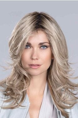 Woman in a large past the shoulders ash blonde 
wavy lace front wig