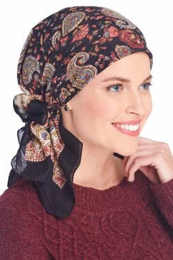 Woman in black paisley cotton head scarf worn as head covering or head wrap for women and cancer patients