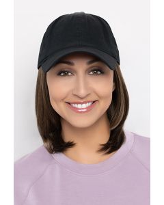 Woman in a solid black baseball cap with shoulder length golden brown hair attached