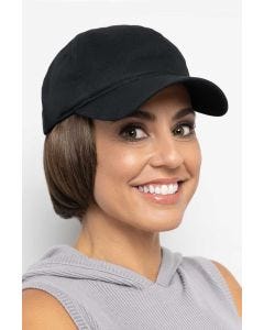 Woman in a solid black baseball cap with chin length light blonde hair attached