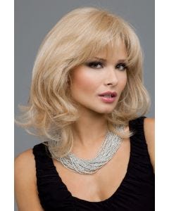 Woman in a shoulder length curly light golden blonde wig with textured bangs and long layers