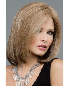 Woman in a dark blonde past the shoulders straight wig with a side part