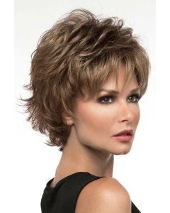 Woman in a petite wavy textured light brown pixie wig with longer piecey layers on top