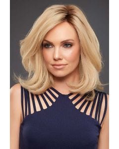 Woman in a petite shoulder length semi-wavy light ash blonde wig with long layers and dark roots