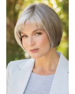 Woman in a chin length platinum blonde blunt bob wig with choppy textured bangs