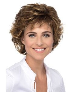 Woman in a chin length short medium brown wig with wispy bangs