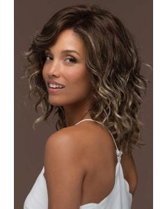 Woman in a past the shoulders curly light brown lace front wig with dark brown roots