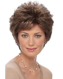 Woman in a short curly warm brown wig with side bangs
