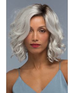 Woman in a shoulder length curly silver lace front wig with dark roots