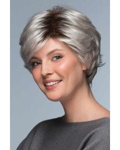 Woman in a long layered light grey pixie wig with side bangs and dark roots