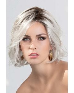 Woman in a past the chin curly white lace front wig