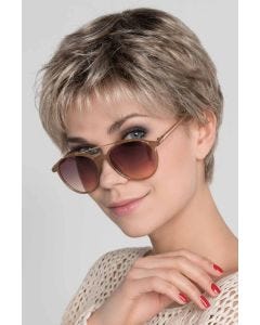 Woman in a cropped classic ash blonde pixie wig with fringe bangs