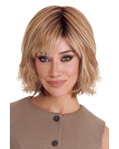 Woman in a past the chin medium auburn layered curly wig with fringe bangs